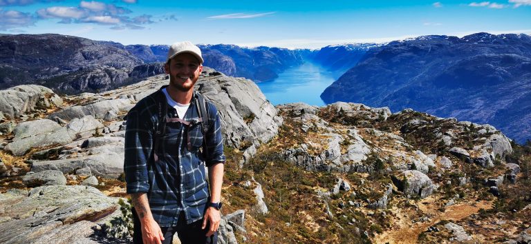 Hiker overlooking Lysefjord during a guided Pulpit Rock hike from Stavanger, Norway